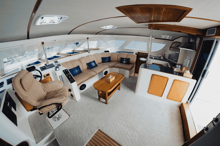 A yacht interior with a sofa, coffee table, and control panel. 3