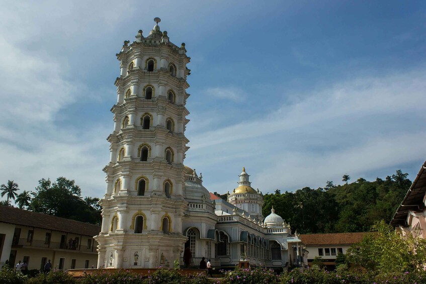 A historic tower with multiple tiers and a dome, surrounded by lush greenery and traditional buildings. 4