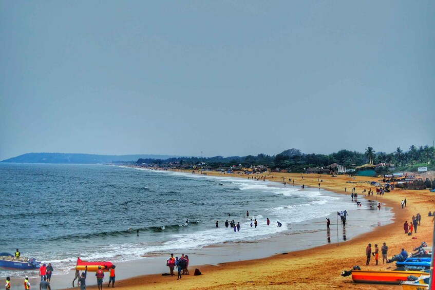 A crowded beach with people, boats, and a clear sky. 2