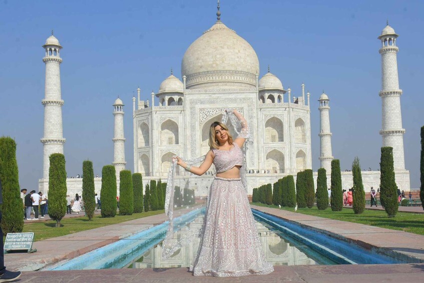 Een persoon in traditionele kleding poseert voor de Taj Mahal. 2