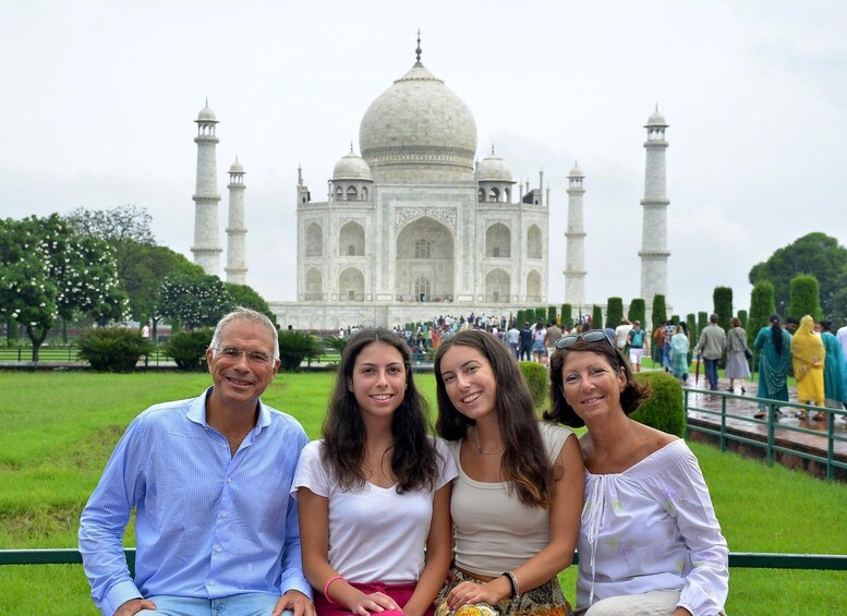 Een groep mensen voor de Taj Mahal, met koepels en minaretten. 3