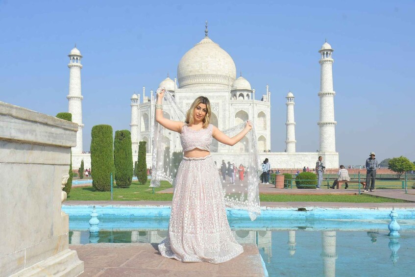 Een persoon in traditionele kleding poseert voor de Taj Mahal. 4