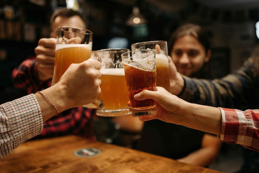 People toasting with beer glasses at a bar. 1