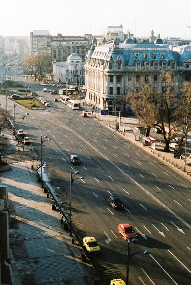 A wide city street with multiple lanes, vehicles, and a prominent blue-domed building. 2