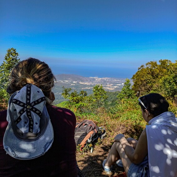 Dos personas sentadas en una colina con vistas a una ciudad. 1