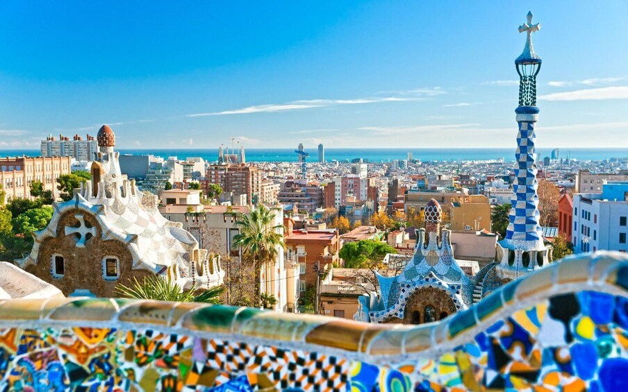 A cityscape with distinctive modern architecture, including a tower with a checkered pattern and a building with a mosaic roof. 2