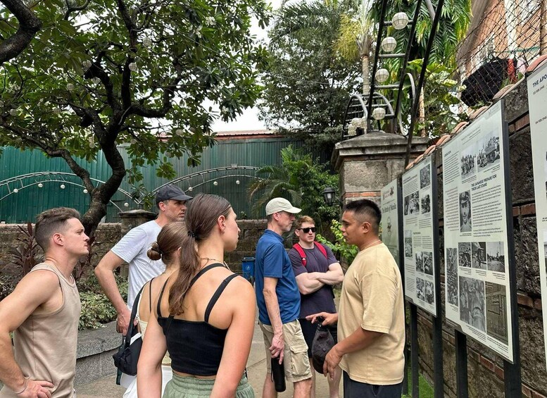 A group of people standing and reading informational plaques outdoors. 5