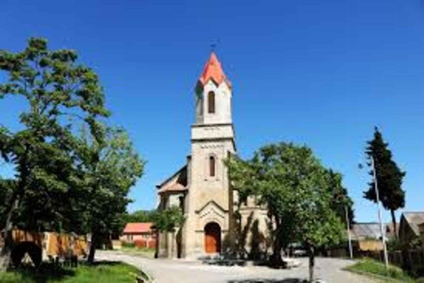 Una iglesia con techo rojo y un campanario. 2