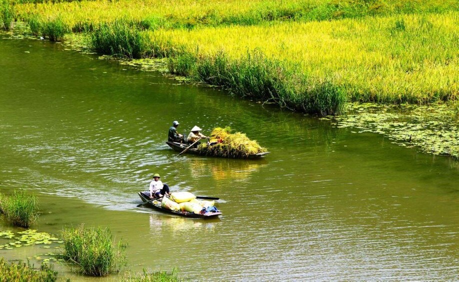 Two people in a boat on a river surrounded by lush greenery. 1