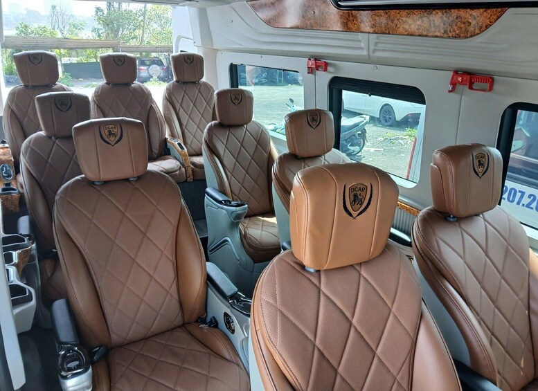A vehicle interior with beige quilted leather seats and a logo on the headrests. 4