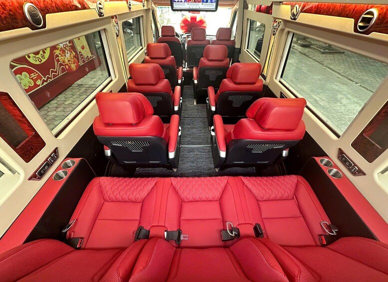 A bus interior with red seats and a central aisle. 3