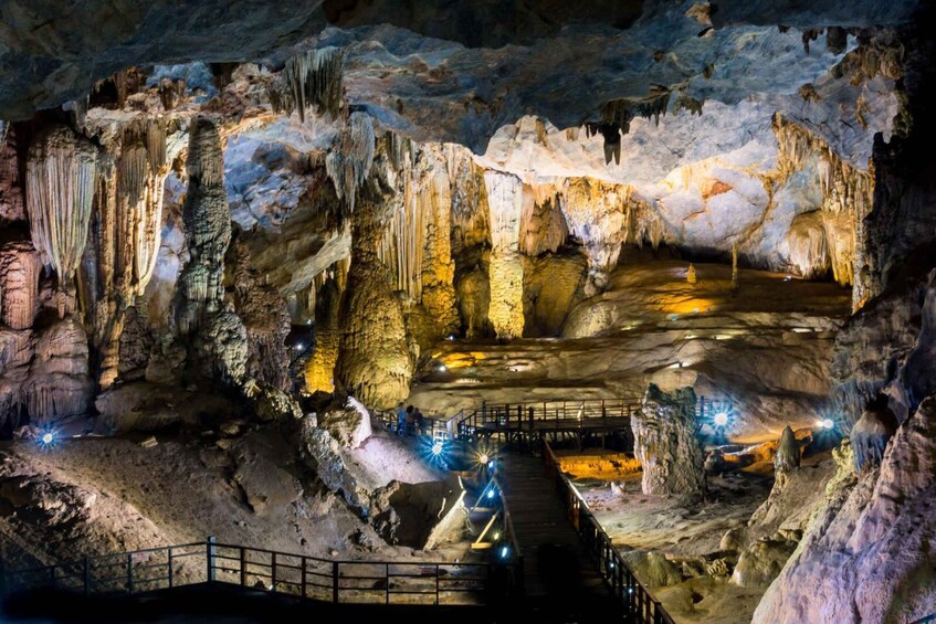 A cave with stalactites and stalagmites, illuminated by artificial lighting. 3