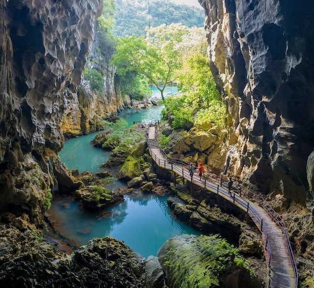 A river flowing through a rocky gorge with a wooden walkway. 4