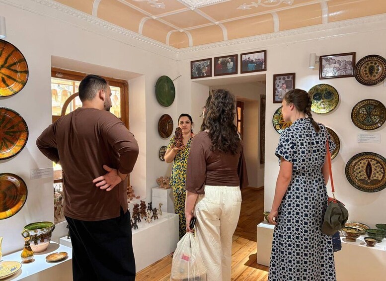A museum interior with visitors observing pottery exhibits. 4