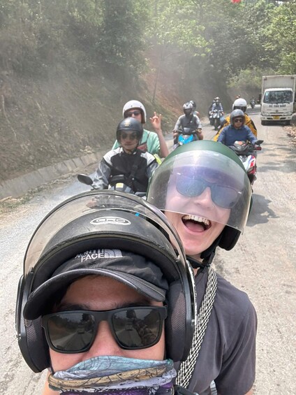 A group of motorcyclists on a road with a guardrail on the left. 4