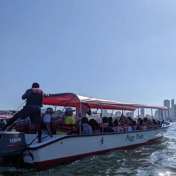 A boat named Peggy Paola with passengers wearing life jackets. 1