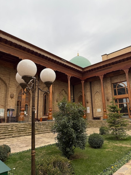 A building with a green dome, brick walls, and ornate columns. 4