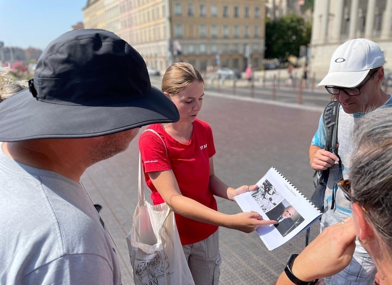 A person handing a booklet to another person. 2