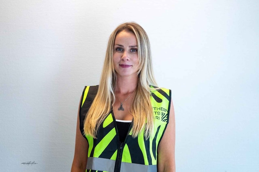 Une personne portant un gilet de sécurité à haute visibilité, orné de rayures noires et jaunes. 1