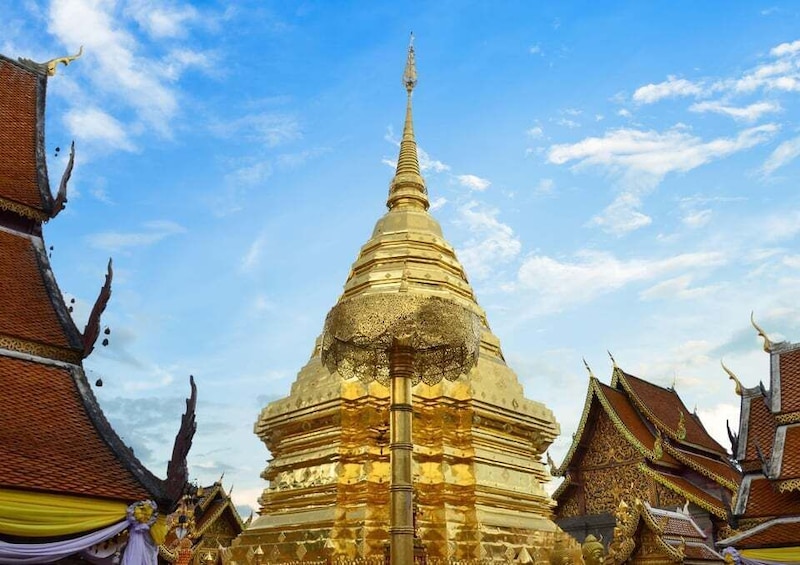 A golden stupa surrounded by traditional Thai architecture. 1