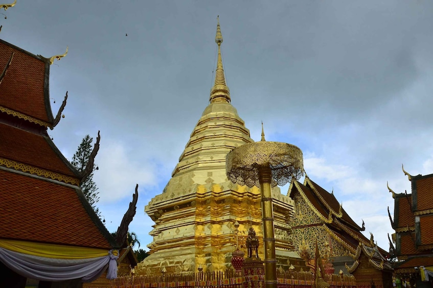 A golden stupa with intricate designs, surrounded by traditional Thai architecture. 5