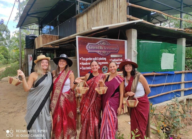 A group of people in traditional attire standing in front of a tea garden. 3