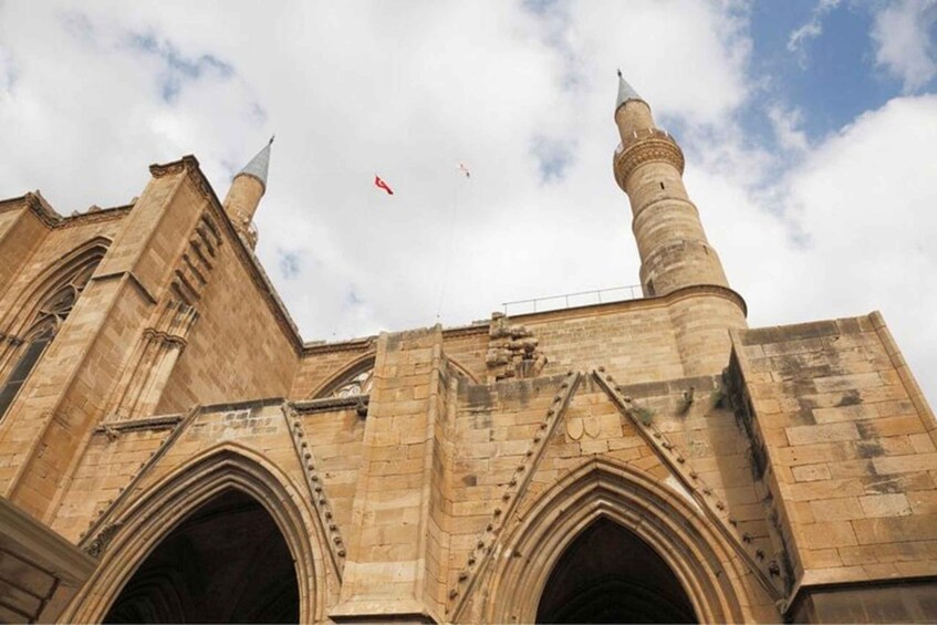 A historic building with pointed arches and two minarets. 1