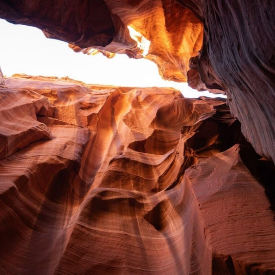 A canyon with layered rock formations and a bright light source. 3