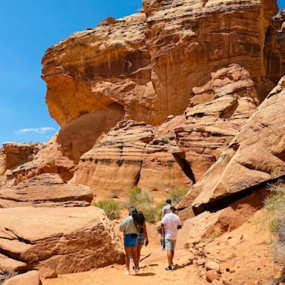 A rocky canyon with hikers walking on a trail. 1