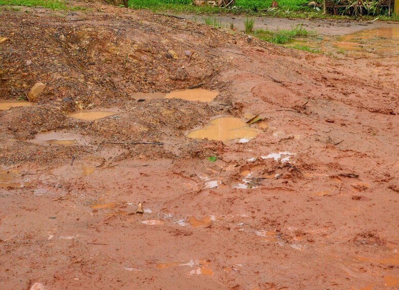 A muddy terrain with puddles and a pile of debris. 4