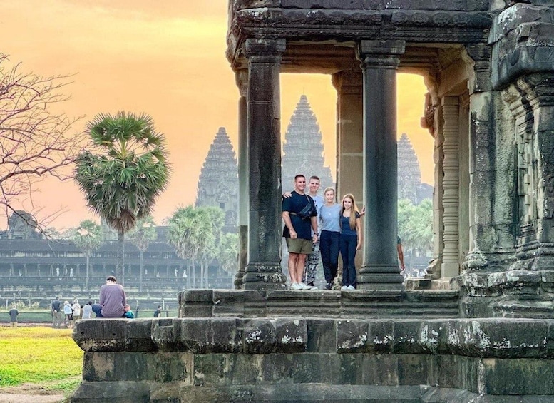 A family posing in front of a temple with a large tree and other structures in the background. 4