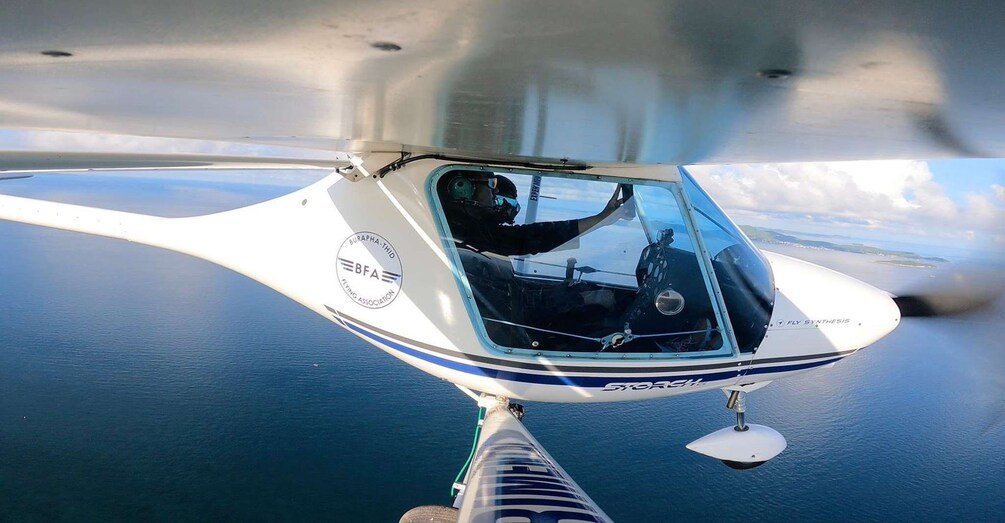 Un helicóptero volando sobre una masa de agua bajo un cielo despejado. 5