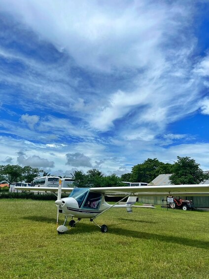 Un pequeño avión blanco sobre un campo cubierto de hierba, con un cielo parcialmente nublado. 4