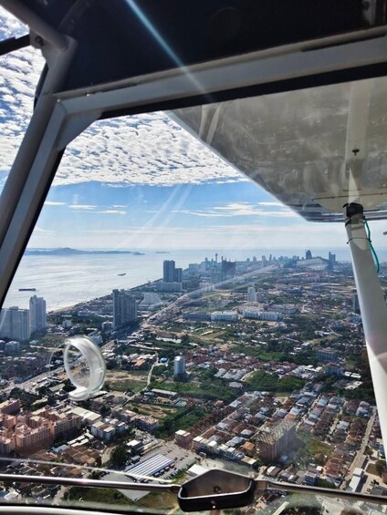 Un paisaje urbano que muestra una combinación de edificios altos y zonas residenciales, visto desde la ventana de un avión. 3
