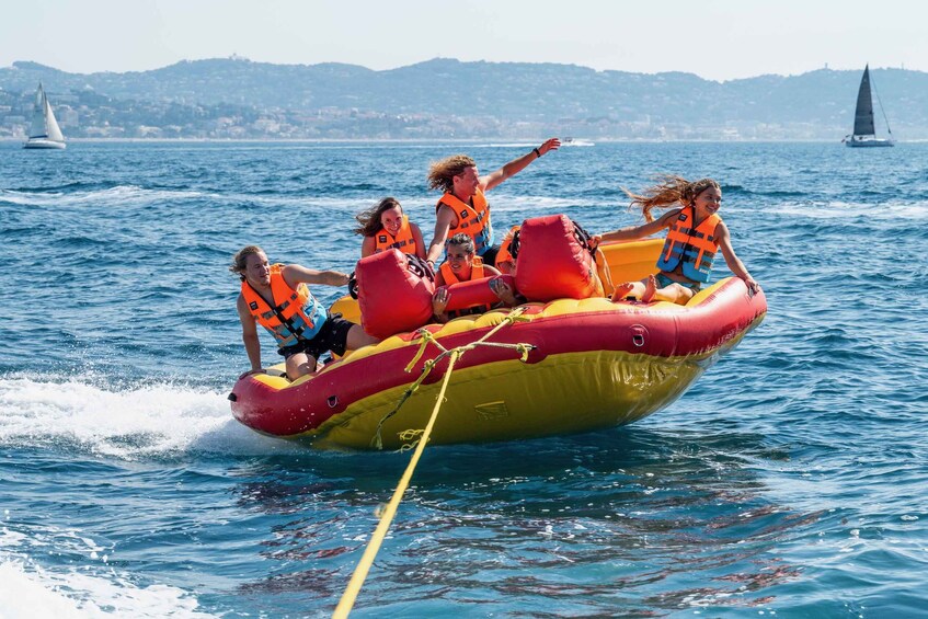 A group of people on a yellow and red inflatable raft in the water. 1