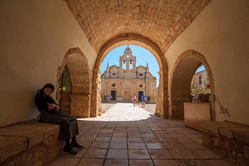 An old stone building with arches, a tiled courtyard, and a bell tower. 4