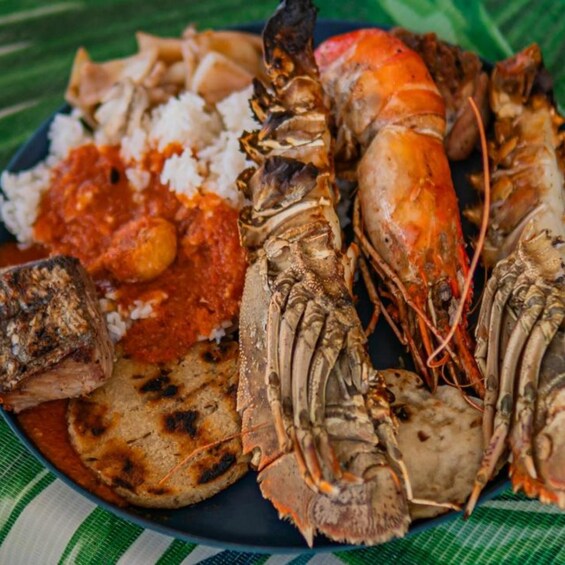 A plate of food including grilled meat, rice, and a whole lobster. 2