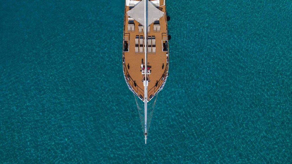 Un bateau doté d’un pont en bois et d’un auvent blanc, flottant sur une eau turquoise et cristalline. 4