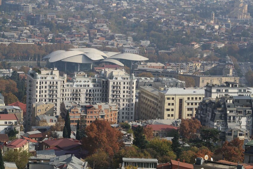A cityscape with a prominent building featuring a unique, modern architectural design with large, curved structures. 2