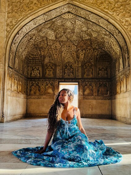 A person sitting in a room with ornate architectural details. 3