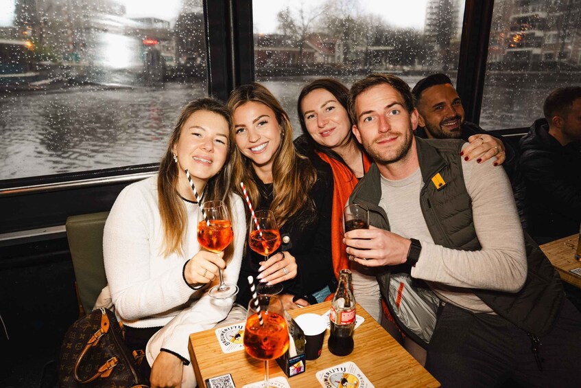 A group of people sitting at a table with drinks and a bottle of Coca-Cola. 3