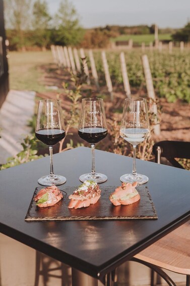 Three wine glasses on a table with food. 1