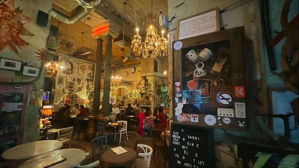 An indoor cafe with tables, chairs, and a menu board. 2