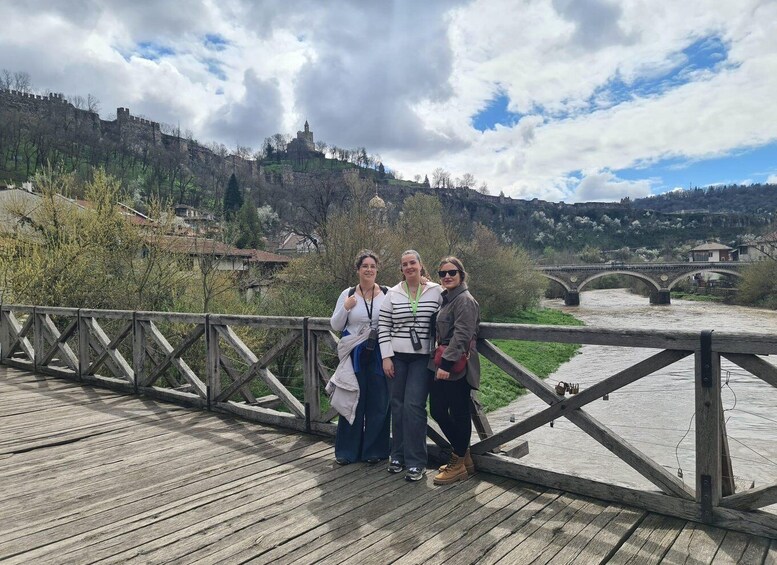 A wooden bridge over a river with a castle in the background. 2