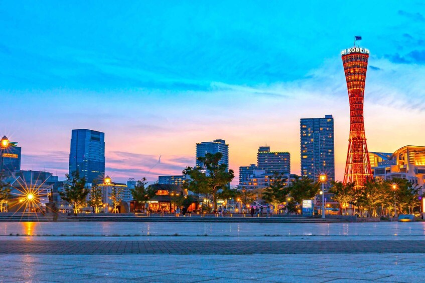 A cityscape at dusk with a prominent tower labeled "OF KOBE" and several modern buildings. 5