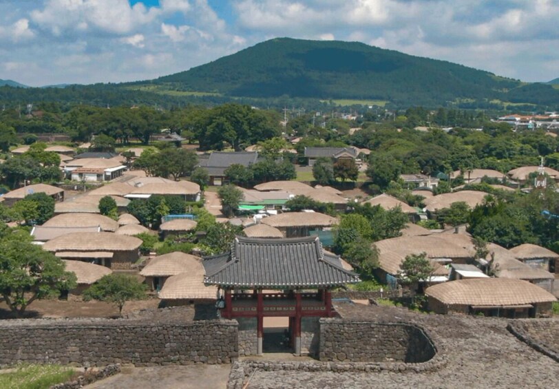 A traditional village with thatched-roof houses and a central pavilion. 1
