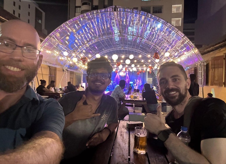A group of people seated at a table with a large illuminated structure in the background. 3