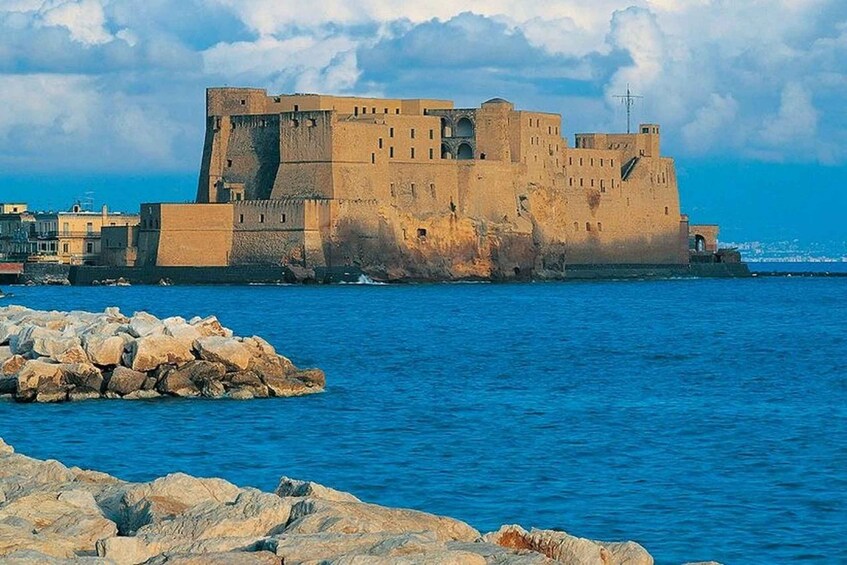 A coastal fortress with a prominent tower, surrounded by rocky shores and calm waters. 4