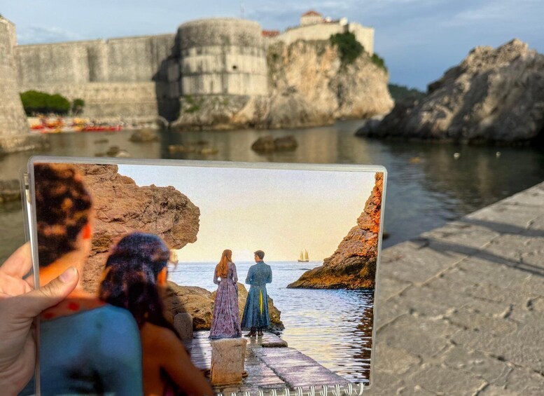 A postcard with a rocky coastline, a castle, and a sailboat in the distance. 3