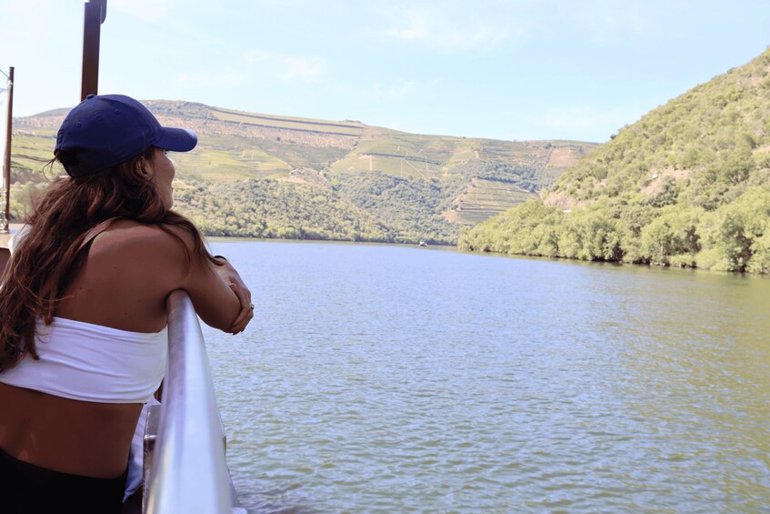 A person on a boat overlooking a calm lake with hills in the background. 2